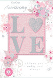 In this image, a romantic anniversary card lies open to reveal a design that quietly celebrates enduring love, like an intimate moment shared on a calm evening in Addington. The central focus is the word LOVE, spelled out in soft, raised glitter that gives the letters a gently shimmering texture. The letter O is transformed into a silver-toned heart, subtly textured so it appears slightly more luminous than the rest, becoming the emotional anchor of the design. Around this word, a ring of delicate blooms in blush and mauve unfurls with a watercolour softness, their edges feathered rather than sharply outlined, as though painted in light. Slender stems, fine vines, and scattered leaves curve gracefully around the letters, creating a sense of movement, like the gentle sway of flowers in a sheltered Addington garden. Tiny details - a hint of swirling filigree, a suggestion of floating petals, almost invisible butterflies - add whimsy without disturbing the calm palette of pastel pinks, silvery greys, and soft whites. At the top and lower sections of the design, the phrases On Our Anniversary and I love you today and always appear in an understated script, each word shaped with the same care a florist might give to placing the final flower in a bouquet. The overall impression is one of treasured intimacy and sincere warmth, the sort of card you would send alongside a hand-tied arrangement delivered locally across Addington to mark the milestones of a shared journey with a message that feels both gentle and deeply heartfelt.